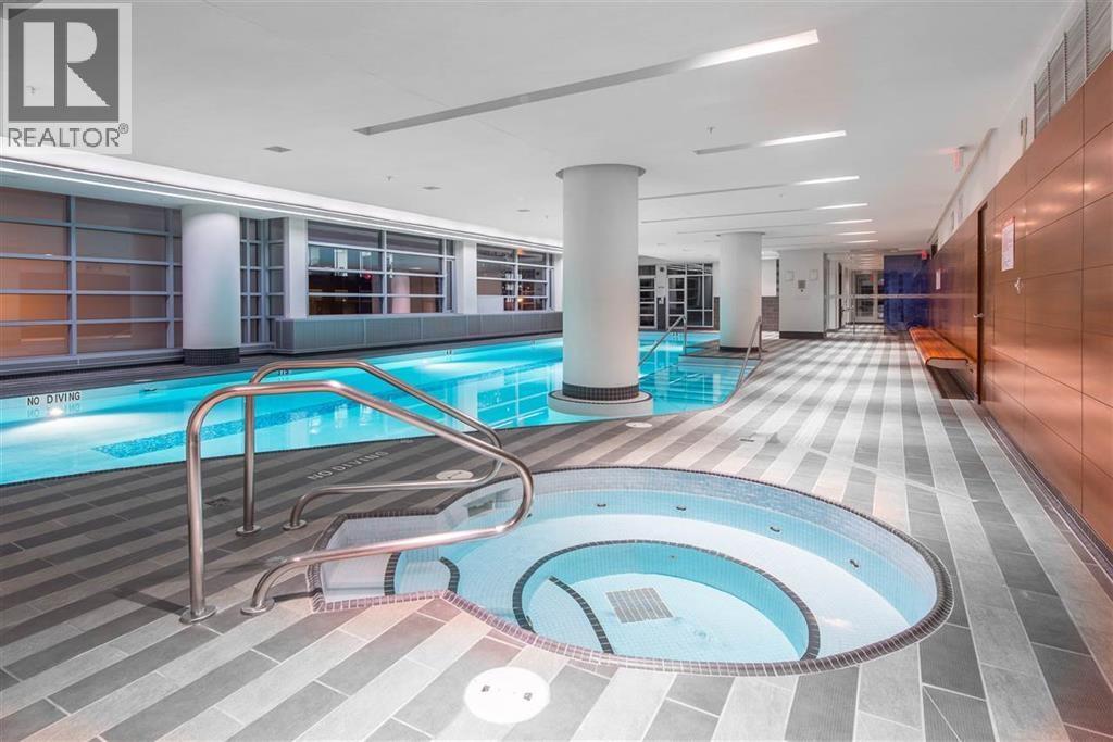 A swimming pool in a well lit indoor swimming pool.