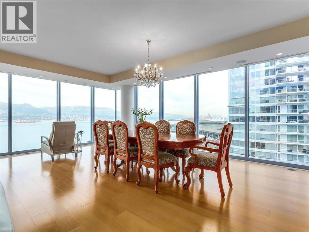 A dining room with a large table and chairs with a view of the city.