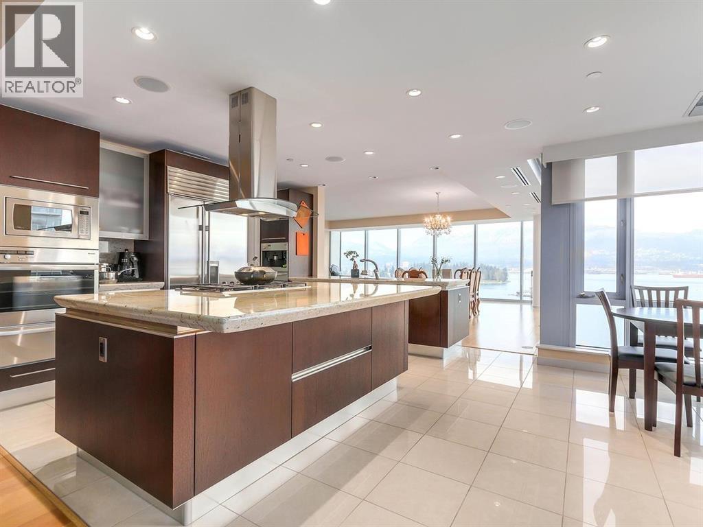 A modern kitchen with a large island and a view of the city.