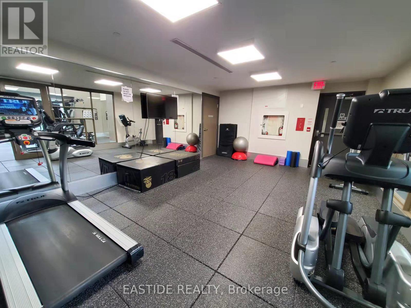 A gym with a treadmill, weights, and exercise equipment.