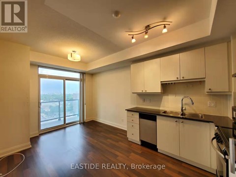 A kitchen with white cabinets and a black countertop.
