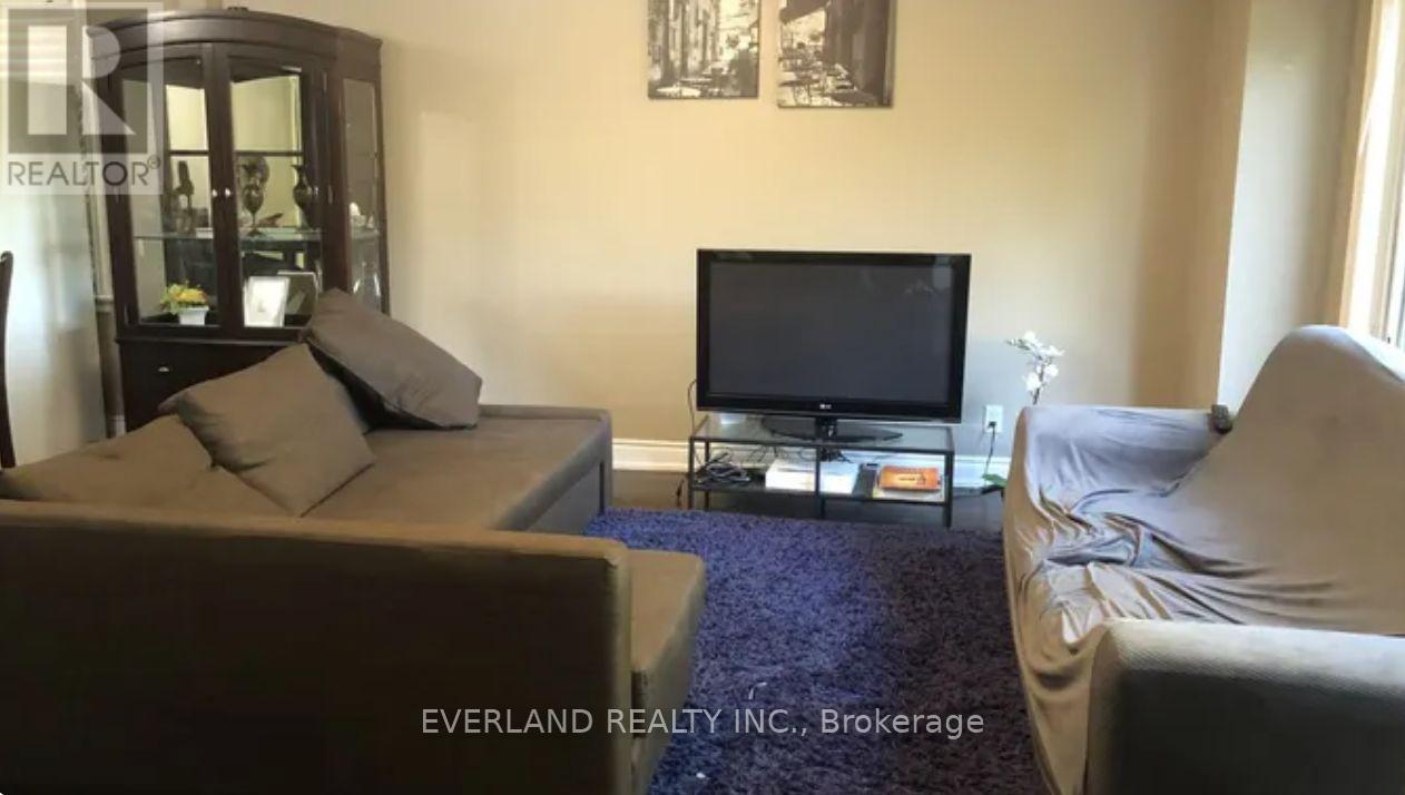 A living room with a couch, a chair, and a television.