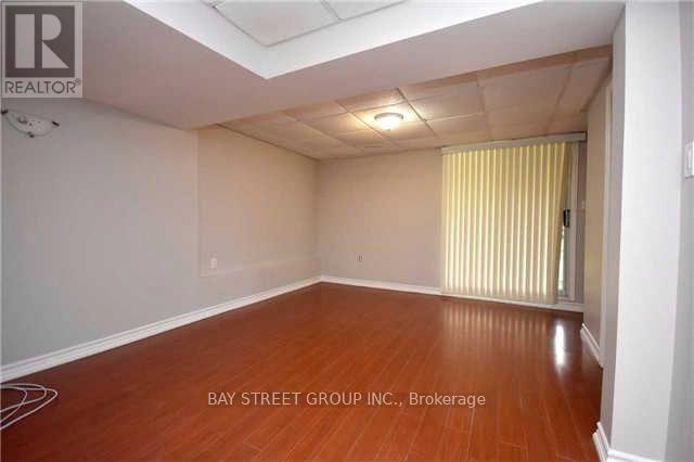 A room with wooden floors and white walls, with a window covered by yellow curtains.