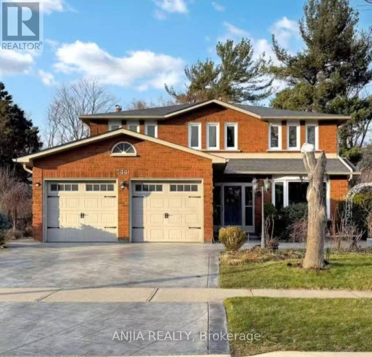A brick house with two garage doors is for sale.