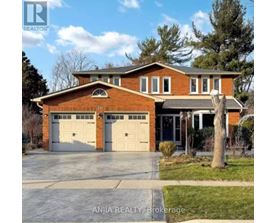 A brick house with two garage doors is for sale.