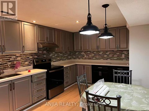 A kitchen with a table and chairs in the foreground and a backsplash of tiles.