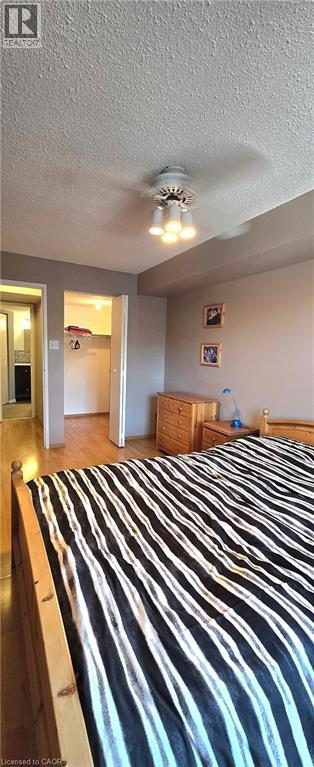 A bedroom with a bed and a ceiling fan.
