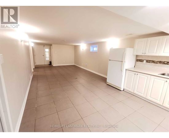 A spacious room with a kitchenette and tiled flooring.