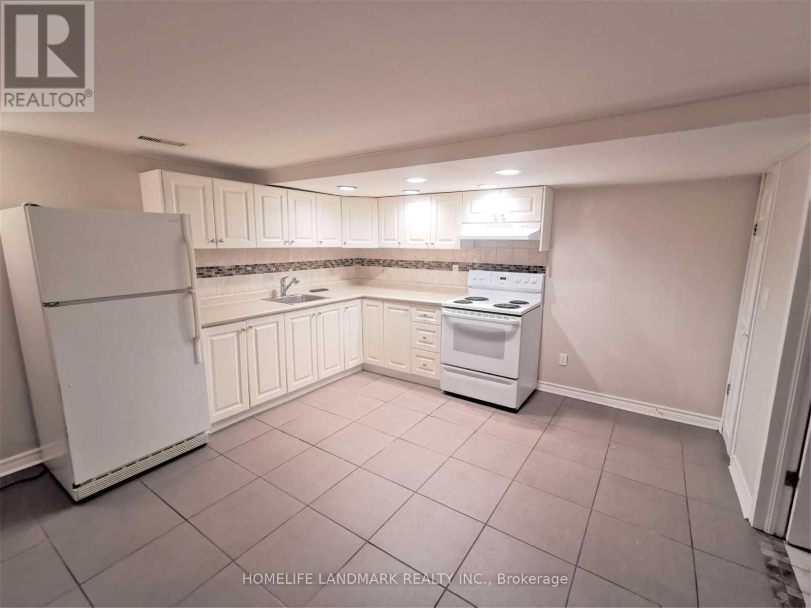 A kitchen with white appliances and cabinets.