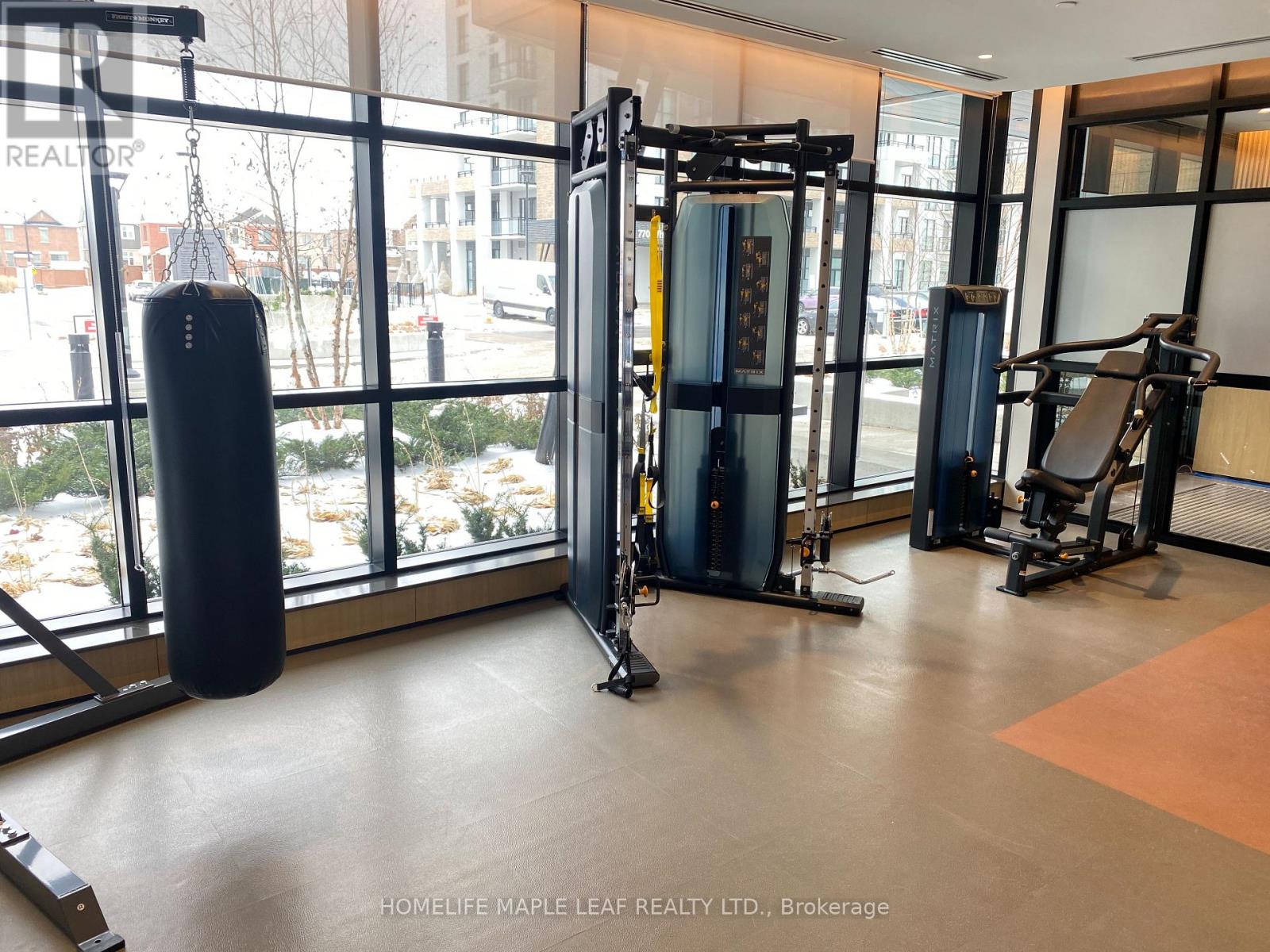 A gym with a punching bag, weights, and exercise equipment.