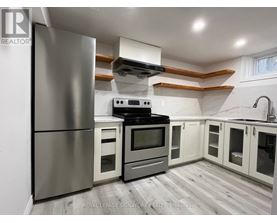 A modern kitchen with a stainless steel refrigerator, oven, and cabinets.