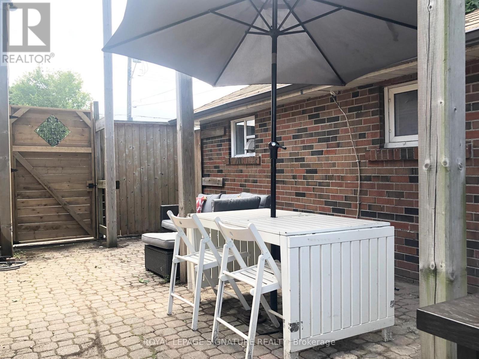 A patio with a table and chairs under an umbrella.