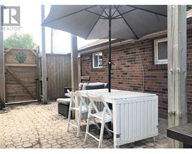 A patio with a table and chairs under an umbrella.
