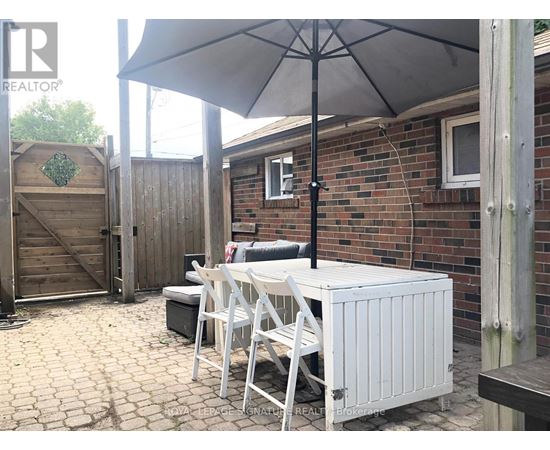 A patio with a table and chairs under an umbrella.