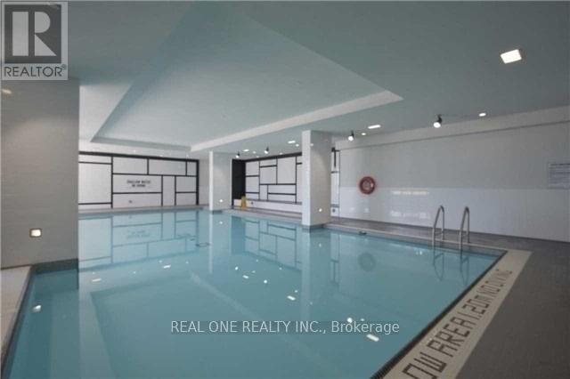 A swimming pool inside a building with the logo of REAL ONE REALTY INC.