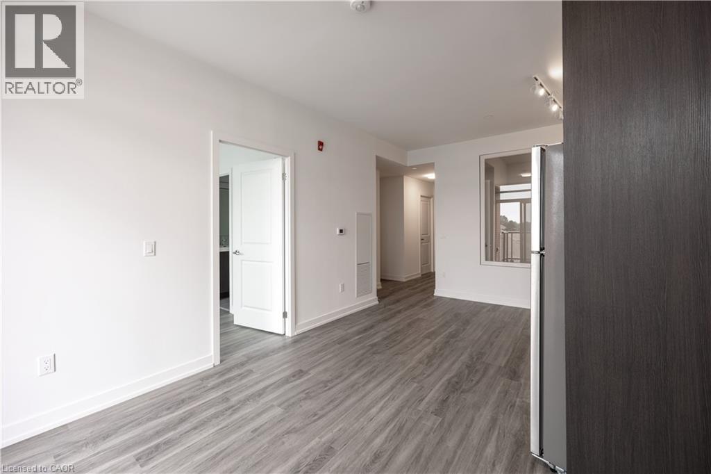 A spacious room with wooden flooring and white walls.