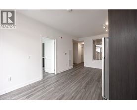 A spacious room with wooden flooring and white walls.