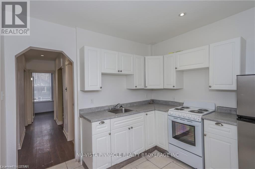 A kitchen with white cabinets and a stove top oven.