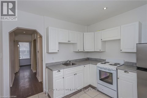 A kitchen with white cabinets and a stove top oven.