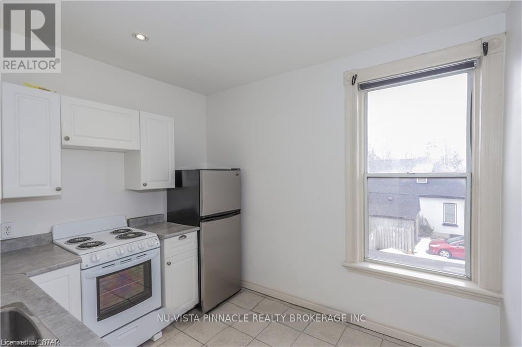 A kitchen with white appliances and cabinets.