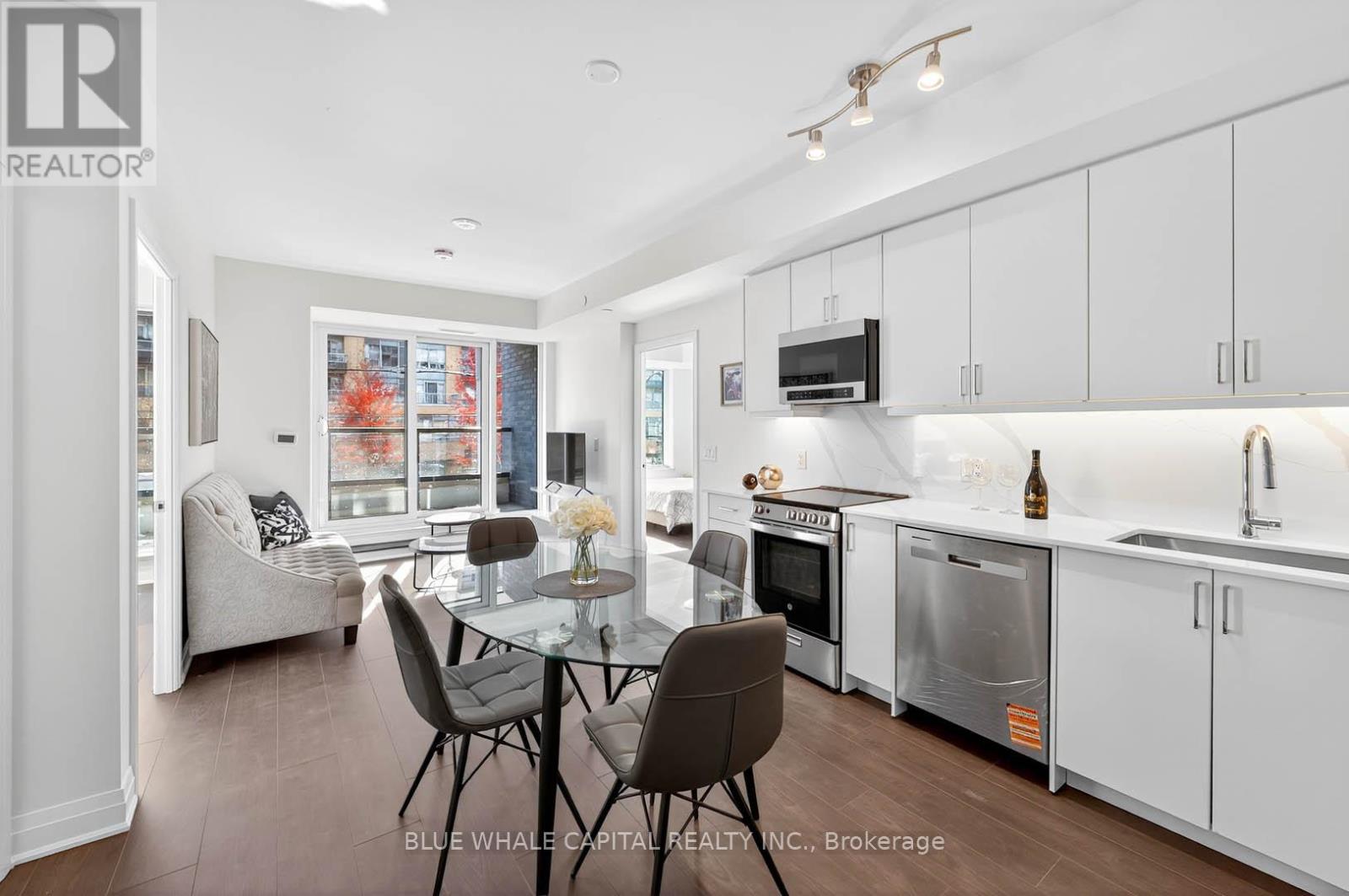 A modern kitchen with white cabinets and a glass table.