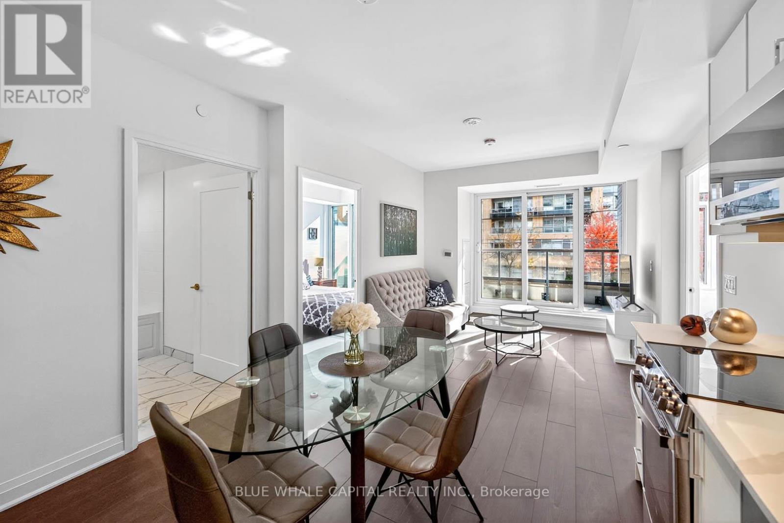 A modern dining room with a glass table and chairs.