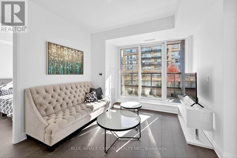 A living room with a white sofa and a glass table.
