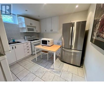 A kitchen with a refrigerator, microwave, and oven.