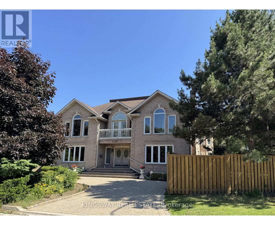 A large house with a driveway and a fence in front of it.