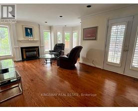 A living room with a fireplace and two chairs.
