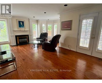 A living room with a fireplace and two chairs.