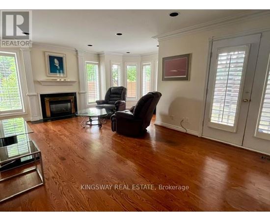 A living room with a fireplace and two chairs.