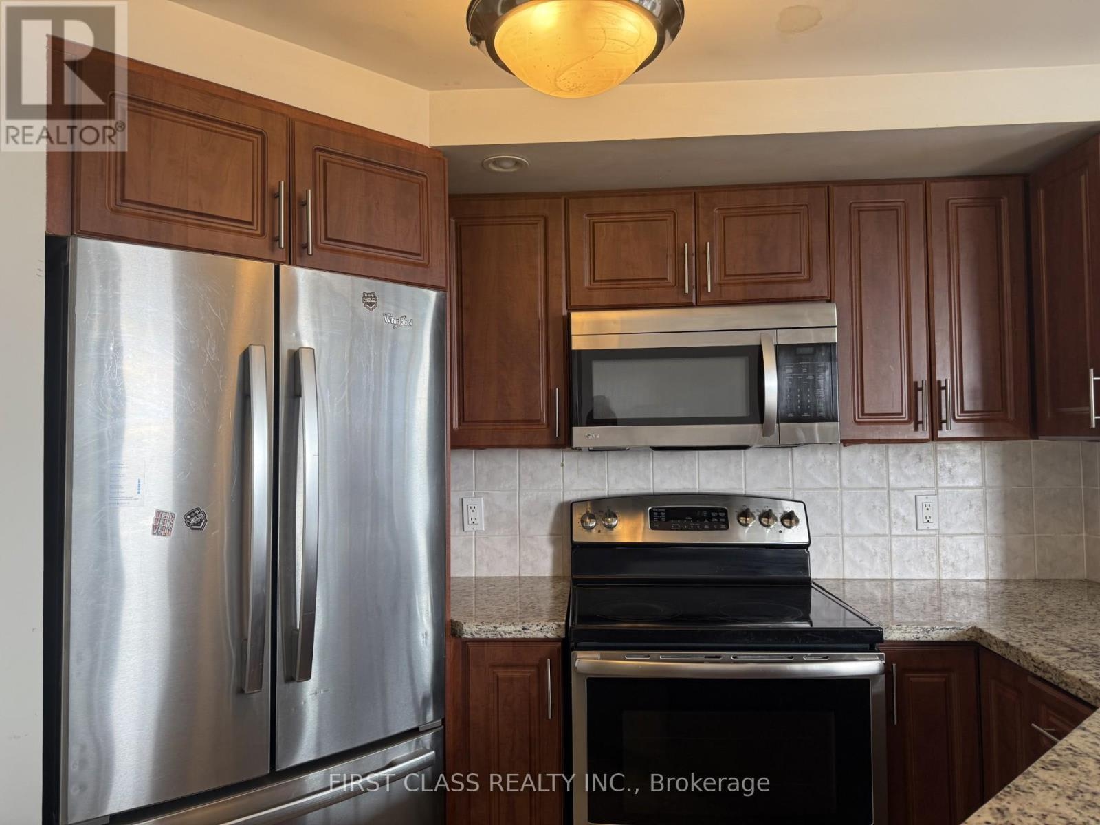 A kitchen with a stainless steel refrigerator and oven.