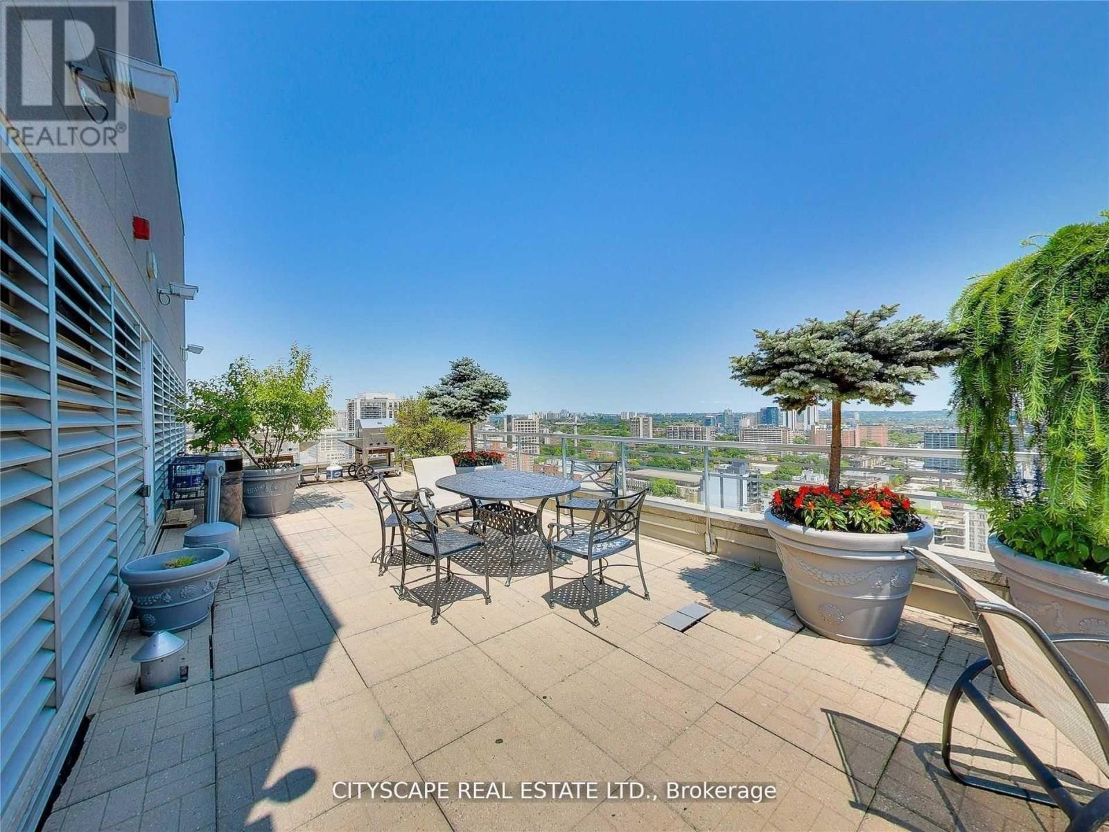 A patio with a table and chairs overlooking a cityscape.