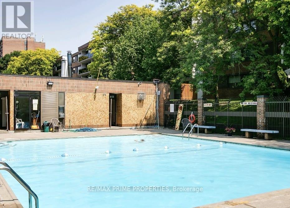 A pool in a backyard with a building in the background.