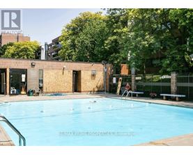 A pool in a backyard with a building in the background.