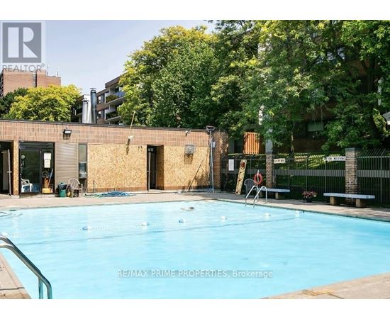 A pool in a backyard with a building in the background.