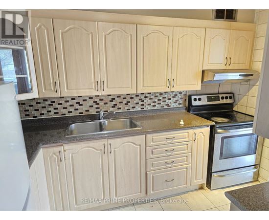 A kitchen with wooden cabinets and a black and white checkered backsplash.