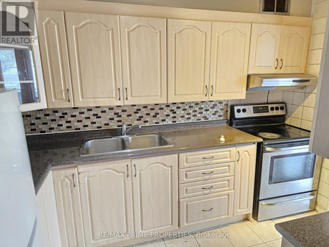 A kitchen with wooden cabinets and a black and white checkered backsplash.