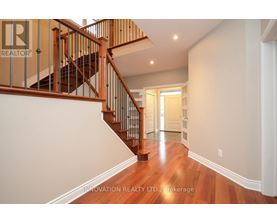 A hallway with a staircase and a doorway.