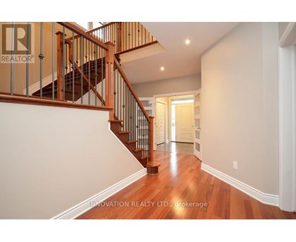 A hallway with a staircase and a doorway.