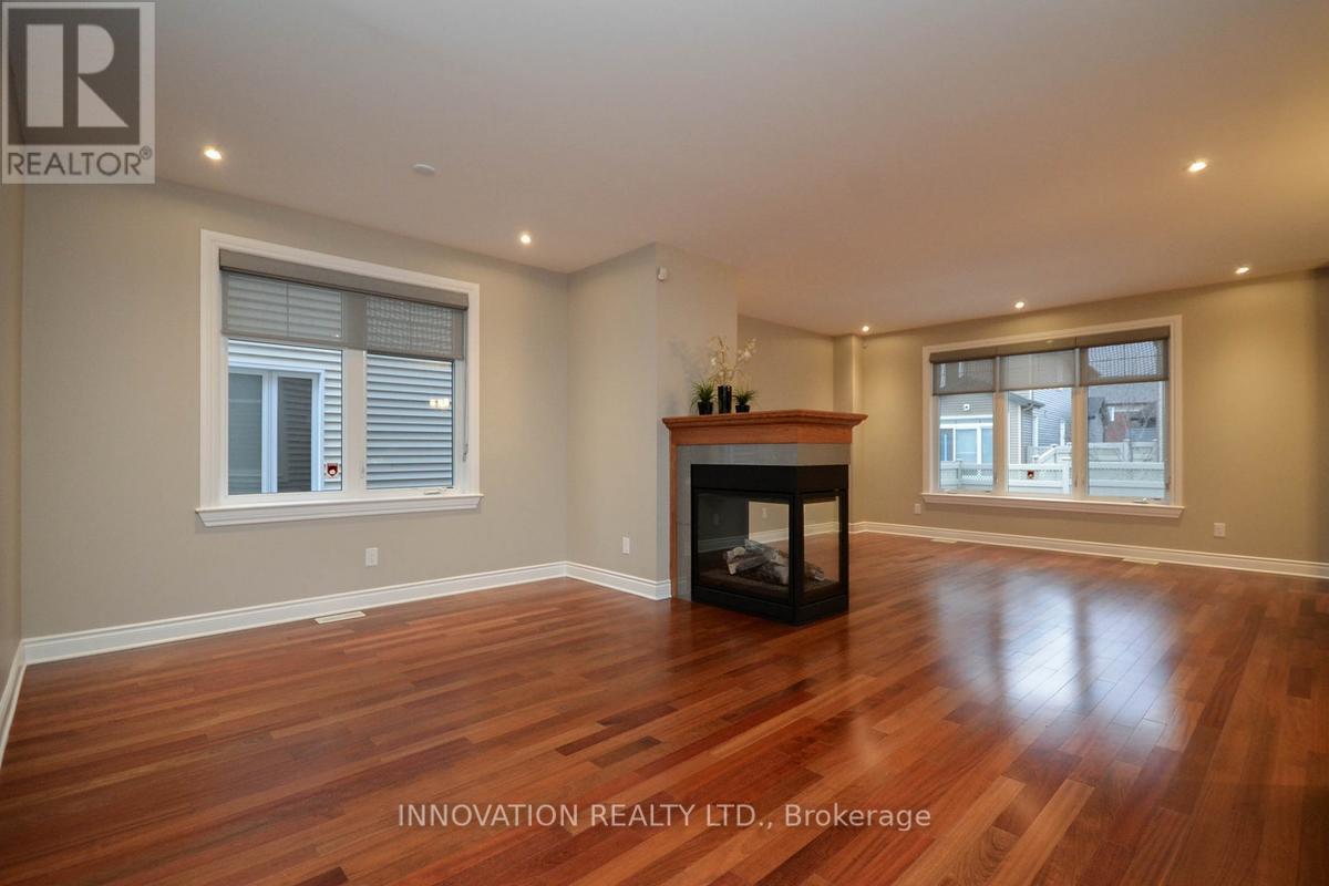 A spacious room with a fireplace and wooden flooring.