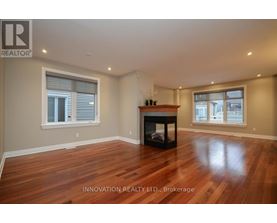 A spacious room with a fireplace and wooden flooring.