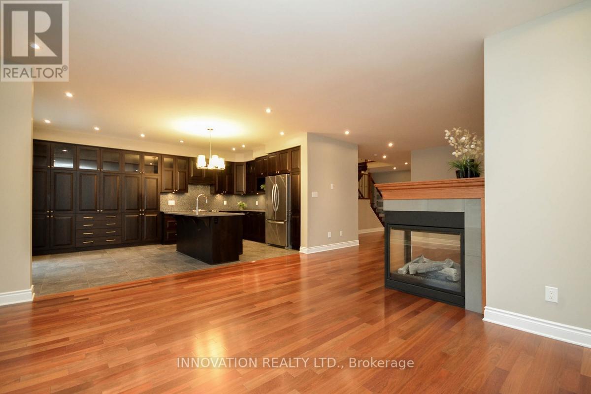 A spacious living room with wood flooring and a fireplace.
