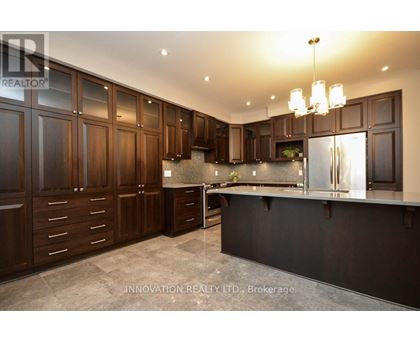 A modern kitchen with dark wood cabinets and a black countertop.