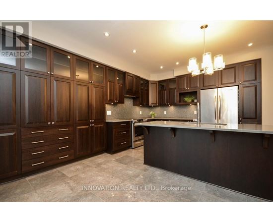 A modern kitchen with dark wood cabinets and a black countertop.