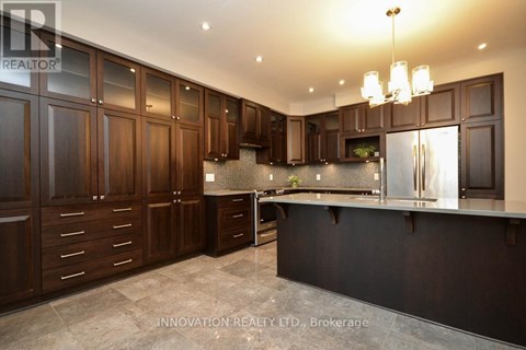 A modern kitchen with dark wood cabinets and a black countertop.