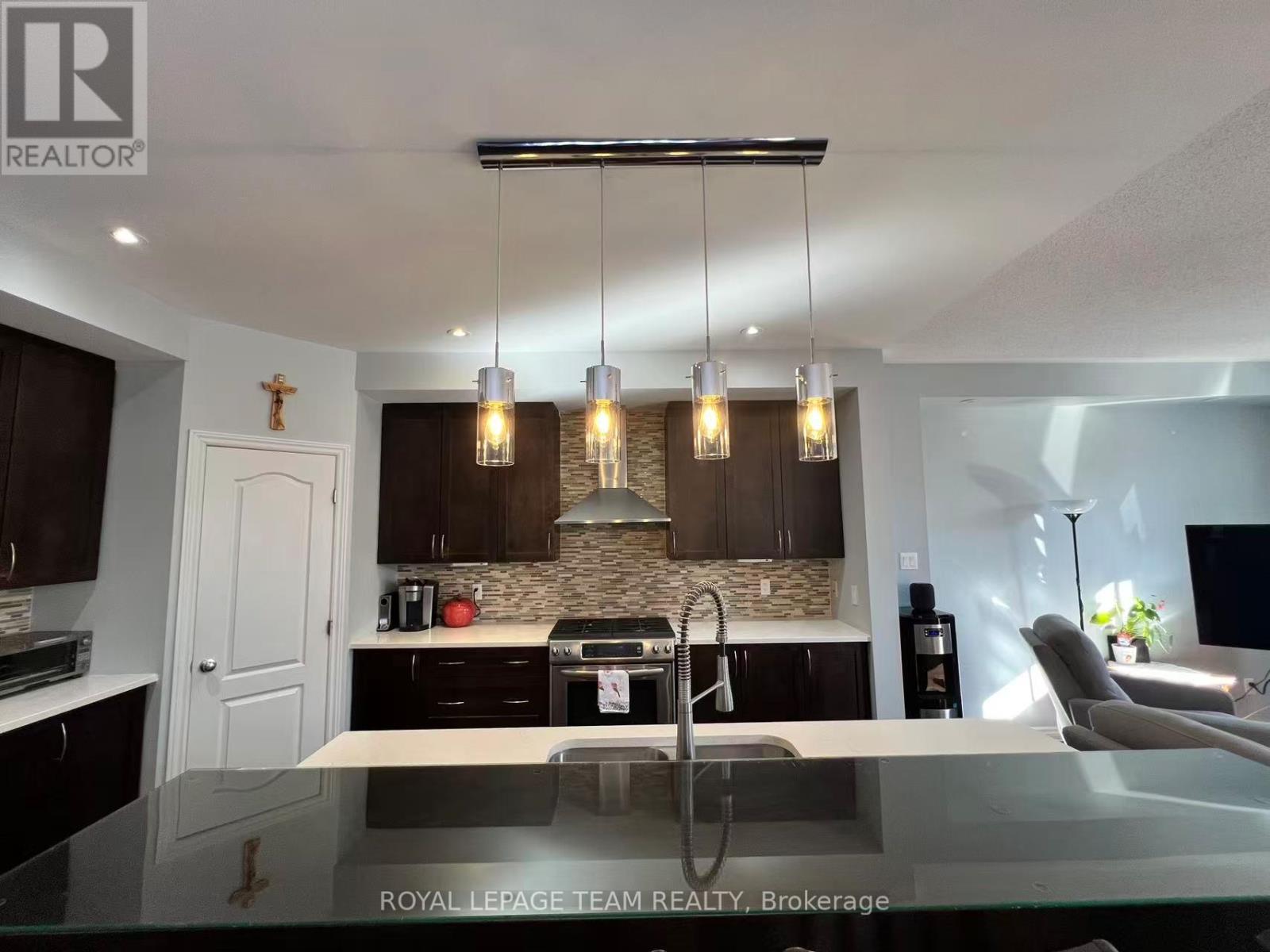 A modern kitchen with dark wood cabinets and a glass island.