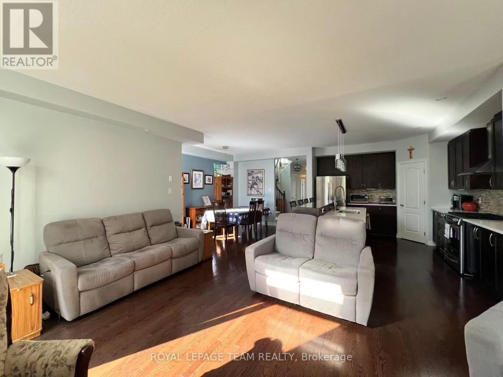 A living room with a couch, chair, and a table with a lamp.