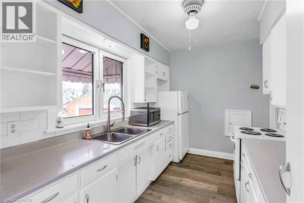 A white kitchen with a sink and a window.